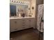 Bathroom features a double sink vanity with white cabinets, a shower/tub combo, and wood-look flooring at 11632 Coastal Way, Indianapolis, IN 46229