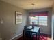Cozy dining room featuring a dark wood table set, red accents, and natural light from the window at 11632 Coastal Way, Indianapolis, IN 46229