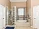 Spacious bathroom featuring a tiled shower, large tub, and natural light at 117 Sawgrass Ct, Lebanon, IN 46052