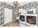 Functional laundry room with modern washer and dryer, stylish wallpaper, and overhead lighting at 117 Sawgrass Ct, Lebanon, IN 46052