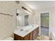 Double sink bathroom boasts patterned wallpaper with views to the bedroom at 11961 Driftstone Dr, Fishers, IN 46037
