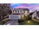 Charming two-story home featuring a well-manicured lawn and an attached two-car garage during sunset at 11961 Driftstone Dr, Fishers, IN 46037