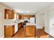 Open kitchen with wooden cabinetry, white appliances, and a functional center island at 11961 Driftstone Dr, Fishers, IN 46037