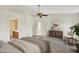 Spacious main bedroom featuring soft lighting, a ceiling fan, and an ensuite bathroom at 11961 Driftstone Dr, Fishers, IN 46037