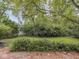 Lush backyard featuring green grass, mature trees, and a charming brick patio at 1207 Pickwick Pl, Indianapolis, IN 46208