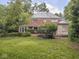 Relaxing backyard view showcasing a brick home, patio and ample green space at 1207 Pickwick Pl, Indianapolis, IN 46208