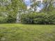 Lush backyard with mature landscaping and a small outbuilding at 1207 Pickwick Pl, Indianapolis, IN 46208