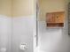 Bright bathroom with built-in wooden storage cabinet, white tile and fixtures at 1207 Pickwick Pl, Indianapolis, IN 46208