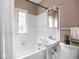 Classic bathroom with a pedestal sink, tub and a window that provides natural light at 1207 Pickwick Pl, Indianapolis, IN 46208