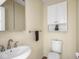 Cozy half bath featuring white fixtures and a charming sink and cabinet design at 1207 Pickwick Pl, Indianapolis, IN 46208