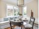 Cozy dining area with a glass table, built-in bench seating, and large windows for natural light at 1207 Pickwick Pl, Indianapolis, IN 46208