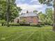 Stunning brick home nestled on a meticulously manicured lawn with mature landscaping and a stately presence at 1207 Pickwick Pl, Indianapolis, IN 46208