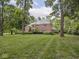 Two-story brick home with a lush green lawn surrounded by mature trees at 1207 Pickwick Pl, Indianapolis, IN 46208