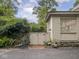 Side exterior featuring a charming brick-paved entrance, wooden fence, and well-maintained landscaping at 1207 Pickwick Pl, Indianapolis, IN 46208