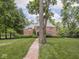 Charming brick home with a brick walkway, lush lawn and mature trees create an inviting exterior at 1207 Pickwick Pl, Indianapolis, IN 46208