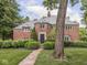 Beautiful brick home featuring a manicured lawn, brick walkway, and mature tree for an inviting entry at 1207 Pickwick Pl, Indianapolis, IN 46208