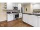 Modern kitchen featuring hardwood floors, stainless steel appliances and white cabinetry at 1207 Pickwick Pl, Indianapolis, IN 46208