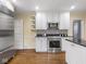 Modern kitchen featuring stainless steel appliances, white cabinetry, and hardwood floors at 1207 Pickwick Pl, Indianapolis, IN 46208