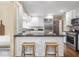 Modern kitchen with stainless steel appliances, white cabinets, and a breakfast bar with seating at 1207 Pickwick Pl, Indianapolis, IN 46208