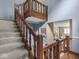 Wooden staircase leads to living room area, showcasing an open layout and natural light at 1207 Pickwick Pl, Indianapolis, IN 46208
