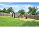 Backyard shed and wood pile behind a wood fence in the grassy backyard at 121 Ursal Ln, Greenwood, IN 46143