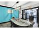 Bright dining room with gray floors, aqua accent wall, modern light fixture, and view into the kitchen at 121 Ursal Ln, Greenwood, IN 46143