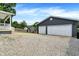 View of the two-car garage, shed, and fire pit from the grassy backyard at 121 Ursal Ln, Greenwood, IN 46143