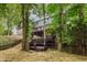 Back exterior with wooden stairs leads to deck; home blends beautifully with the surrounding mature trees at 12118 Castle Row Overlook, Carmel, IN 46033