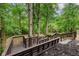 Wooden deck with stairs descending into a backyard forest at 12118 Castle Row Overlook, Carmel, IN 46033