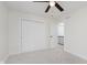 Cozy bedroom featuring a ceiling fan, closet, neutral carpet, and a door leading to another level at 12118 Castle Row Overlook, Carmel, IN 46033