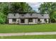 Inviting home featuring stone accents, covered entryway, lush lawn, and mature trees at 12118 Castle Row Overlook, Carmel, IN 46033