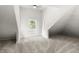 Attic bedroom featuring neutral carpet, sloped ceilings and bright window at 1217 Newman St, Indianapolis, IN 46201