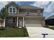 Two-story home featuring a manicured lawn, brick facade, attached two-car garage, and welcoming entrance at 1326 Foxtail Ln, Greenwood, IN 46143