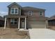 Two-story brick home featuring a two-car garage, covered entry, and well-maintained landscaping at 1326 Foxtail Ln, Greenwood, IN 46143
