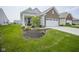 Inviting home featuring a covered porch, brick accents, and an attached two-car garage at 13448 Mosaic St, Fishers, IN 46037