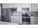 Kitchen features stainless steel appliances, white cabinets, and elegant quartz countertops, perfect for cooking at 13448 Mosaic St, Fishers, IN 46037
