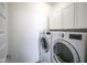 Laundry room featuring updated washer and dryer units, modern shaker cabinets, and a bright white color palette at 13448 Mosaic St, Fishers, IN 46037