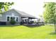 Lush backyard with a covered patio featuring outdoor seating and well-manicured lawn at 13820 Woodside Hollow Dr, Carmel, IN 46032
