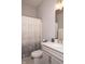 Well-lit bathroom featuring a white vanity, toilet and patterned shower curtain at 13820 Woodside Hollow Dr, Carmel, IN 46032