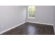 Bright bedroom featuring wood flooring, white trim, and a large window at 13820 Woodside Hollow Dr, Carmel, IN 46032