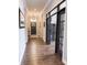 Hallway with dark wood floors leading to the front door and a view into the living room at 13820 Woodside Hollow Dr, Carmel, IN 46032