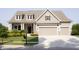 Charming two-story home with a manicured lawn, pergola-covered garage, and inviting front porch at 13820 Woodside Hollow Dr, Carmel, IN 46032