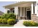 Inviting front porch with stone accents, decorative plants, and a welcoming entrance at 13820 Woodside Hollow Dr, Carmel, IN 46032