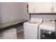 Functional laundry room equipped with modern appliances, storage cabinets, and a folding table at 13820 Woodside Hollow Dr, Carmel, IN 46032
