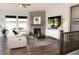 Cozy living room featuring a stone fireplace, a plush white couch, and lots of natural light at 13820 Woodside Hollow Dr, Carmel, IN 46032