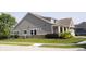 Well-maintained home exterior featuring stone accents, tidy landscaping, and a lush green lawn at 13820 Woodside Hollow Dr, Carmel, IN 46032
