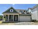 Charming green home boasts a stone-accented facade and a convenient two-car garage, offering curb appeal and practicality at 14277 Coyote Rdg, Noblesville, IN 46060