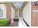 Inviting front entrance with brick accents, a well-kept lawn, and a charming covered porch at 15308 Wolf Run Ct, Noblesville, IN 46060