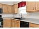 A kitchen close-up featuring gray counter-tops, wooden cabinets, and black appliances at 15308 Wolf Run Ct, Noblesville, IN 46060