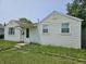 Home exterior shows the front entrance, window and vinyl siding needing lawn maintenance at 1601 S Biltmore Ave, Muncie, IN 47302